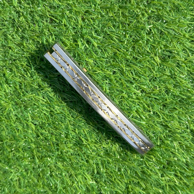 Damascus pocket knife closed showing intricate engraving details and brass accents