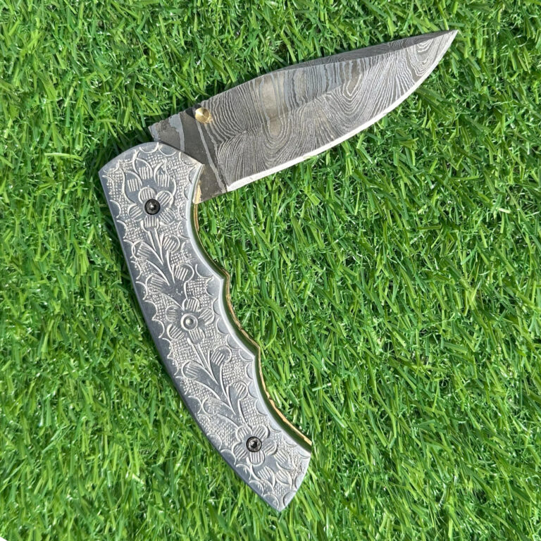 Full Damascus knife open displaying wave pattern blade and engraved Damascus handle