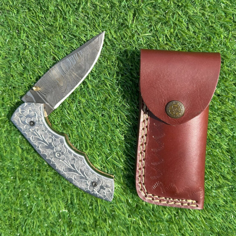 Full Damascus steel folding knife with hand-engraved floral handle and premium leather sheath