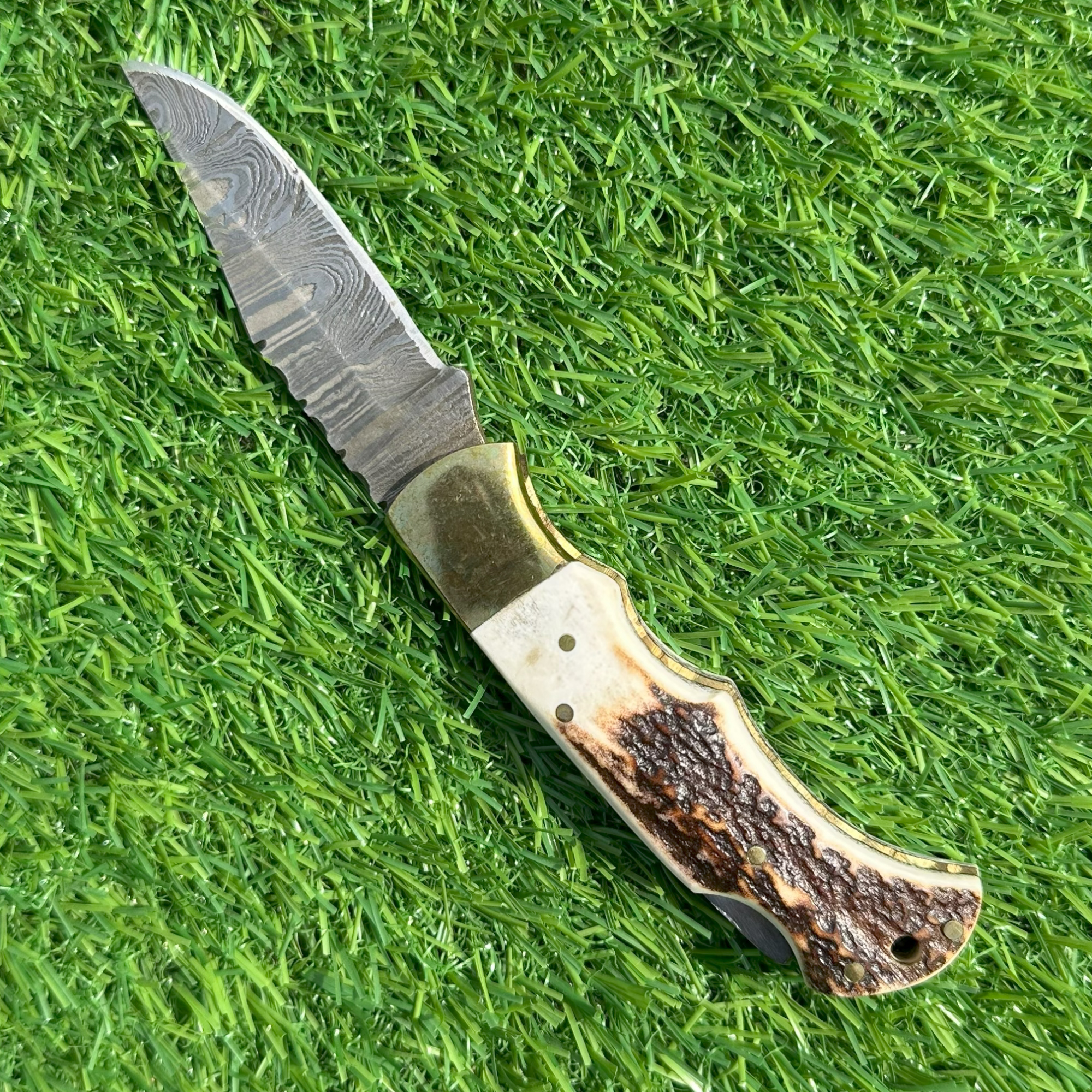 Full Damascus steel blade open showing unique wave pattern and brass guard