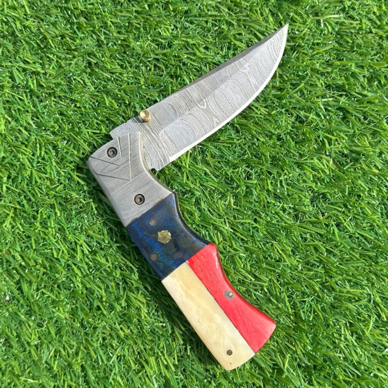 Hand forged Damascus blade fully open showing unique wave pattern and engraved bolsters